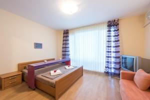 a room with a bed and a couch and a television at GT Privilege Fort Beach Apartments in Elenite +52 photos