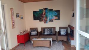 sala de estar con sillas, mesa y pinturas en Ferienhaus Bad Waltersdorf, en Bad Waltersdorf