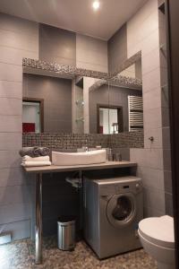 a bathroom with a sink, toilet and mirror at Apartament Onyx in Poznań