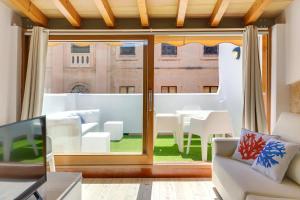 sala de estar con puerta corredera de cristal con mesa y sillas en Urban Suites Palma - Turismo de Interior en Palma de Mallorca