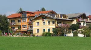 une grande maison avec une pelouse devant elle dans l'établissement Ferienhotel Herzog, à Neumarkt am Wallersee
