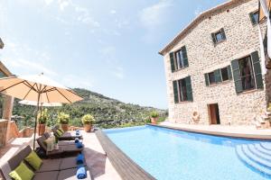 een villa met een zwembad en een gebouw bij Villa Can Sarales - Deia in Deia