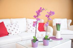 a living room with two vases with flowers on a table at Villa Can Sarales - Deia in Deia