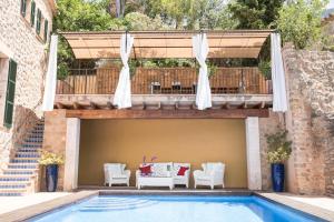 an outdoor patio with a table and chairs and a pool at Villa Can Sarales - Deia in Deia