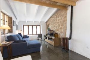 a living room with a blue couch and a tv at Villa Es Coco, Soller in Port de Soller