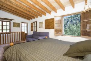 a bedroom with a large bed and a window at Villa Es Coco, Soller in Port de Soller
