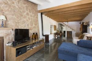 sala de estar con TV y sofá azul en Villa Es Coco, Soller, en Puerto de Sóller