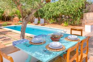 una mesa azul con sombreros y platos junto a una piscina en Villa Palma, Establiments, en Palma de Mallorca