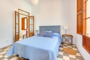 a bedroom with a blue bed and a checkered floor at Villa Palma, Establiments in Palma de Mallorca