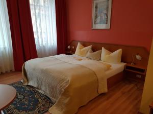 a bedroom with a large bed with red walls at Hotel Am Kuhbogen in Hof