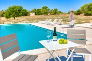 uma mesa com copos de vinho e frutas ao lado de uma piscina em Villa Amazing Vilafranca em Vilafranca de Bonany