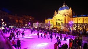 a group of people skating on an ice rink in front of a building at Apartments City of Hearts 1 & 2 in Zagreb