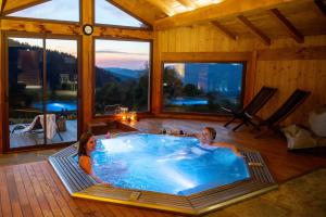 a man and woman sitting in a hot tub in a house at Là Haut & Spa in Ventron