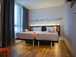 מיטה או מיטות בחדר ב-easyHotel Lisbon
