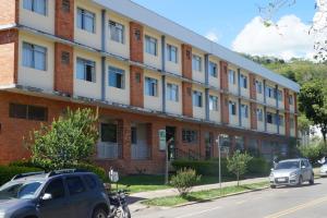 un edificio con coches estacionados frente a él en Hotel do CEE en Viçosa