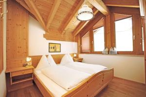 Un dormitorio con una cama en una habitación con techos de madera. en Appartement Dertnig, en Flachau