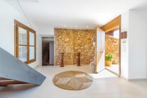 a living room with a stone wall at VILLA ES TRENC - Sa Sinia Vella in Campos