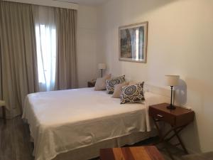 Un dormitorio con una gran cama blanca y una ventana en Disfrutando buenos aires en Buenos Aires