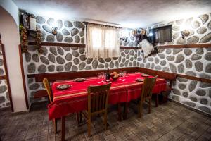 a dining room with a red table and chairs at Vien Guest House in Bansko