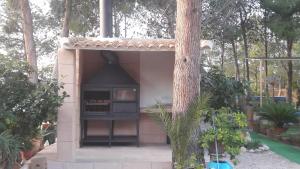un pequeño edificio con una estufa en un jardín en Casa Rural Mi Campo, en Fenazar