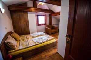 ein Schlafzimmer mit einem Bett und einem Stuhl in einem Zimmer in der Unterkunft Vien Guest House in Bansko