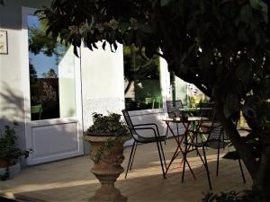 um pátio com uma mesa e cadeiras e uma planta em Casa Cipriani em Potenza Picena