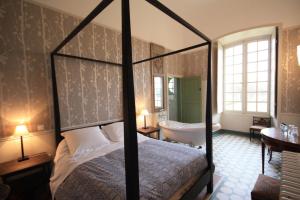 a bedroom with a bed and a tub and a sink at Abbaye de Reigny - Esprit de France in Vermenton