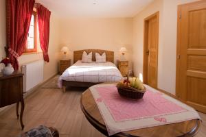 a bedroom with a bed and a table with a basket of fruit at La Ferme de Louise in Hohengoeft