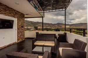 einen Balkon mit Stühlen und Tischen sowie Bergblick in der Unterkunft Hotel Suite Naylamp Zyon in Jaén