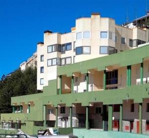 シエラネバダにあるPenibetico ERB Alojamientosの山の隣の大きな緑白の建物