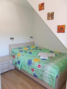a bedroom with a bed with a floral bedspread at Gorštak in Kopaonik