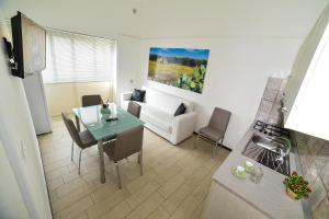 a kitchen and living room with a table and a couch at Case Vacanza Via Mozart in Porto Cesareo
