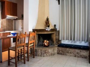 Villa Dimitris في Kalamitsi Amygdali: مطبخ مع موقد مع طاولة وكراسي