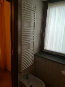 a bathroom with a white sink and a window at guado cannavina in Capracotta