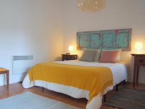 una camera da letto con un grande letto con una coperta gialla di Monte dos Freixos Country House a São Lourenço de Mamporcão