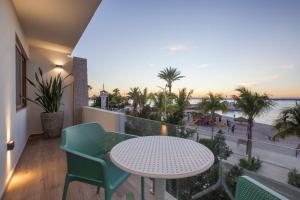 a balcony with a table and chairs and a view of the beach at Casa al Mar in La Paz