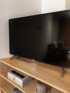 einen großen Flachbild-TV auf einem Holzständer in der Unterkunft Central Suites - Špindlerův mlýn in Špindlerův Mlýn