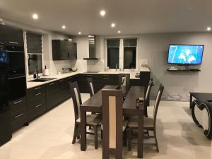 リマノバにあるHoliday home Limanowaのキッチン(ダイニングテーブル、壁掛けテレビ付)