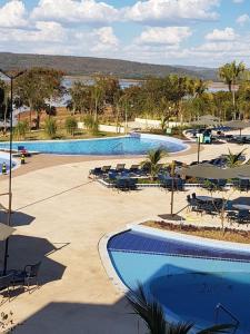 2 Swimmingpools mit Tischen und Stühlen in einem Resort in der Unterkunft SALINAS PARK RESORT in Salinópolis