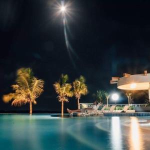 una piscina notturna con palme di SALINAS PARK RESORT a Salinópolis