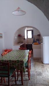 a kitchen and dining room with a table and a refrigerator at Trulli in Valle D'Itria in Cisternino