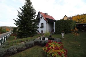 Gernrode - HarzにあるFerienwohnung"Harzliebe"の庭の花と木のある白い家