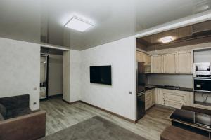 an empty kitchen with a couch and a television at Greatest Luxury Apartment in Sumy