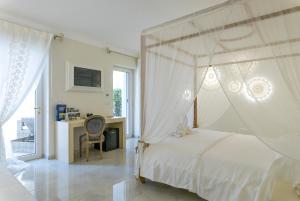 ein Schlafzimmer mit einem weißen Bett mit Himmelbett in der Unterkunft Il Lusso Del Silenzio in Ugento