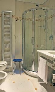 a bathroom with a shower and a stool in it at Dado Hotel International in Parma