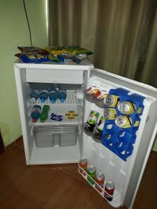 an open refrigerator filled with drinks and soda cans at Hotel Chalé Ji-Parana in Ji-Paraná