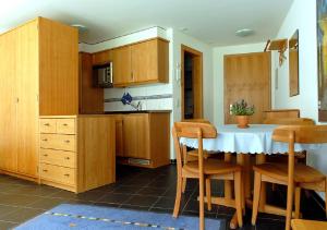 eine Küche mit Holzschränken sowie einem Tisch und Stühlen in der Unterkunft Apartment Brunnmatt in Zermatt