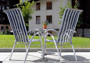 2 Stühle und ein Tisch vor einem Haus in der Unterkunft Apartment Brunnmatt in Zermatt