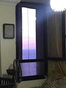 a bedroom with a window with a view of the ocean at Cozy new 2 BD Amazing beach view Next to Hilton hotel Family only !العائلات فقط in Alexandria
