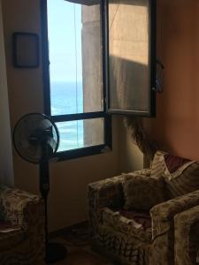 a living room with a fan and a window at Cozy new 2 BD Amazing beach view Next to Hilton hotel Family only !العائلات فقط in Alexandria